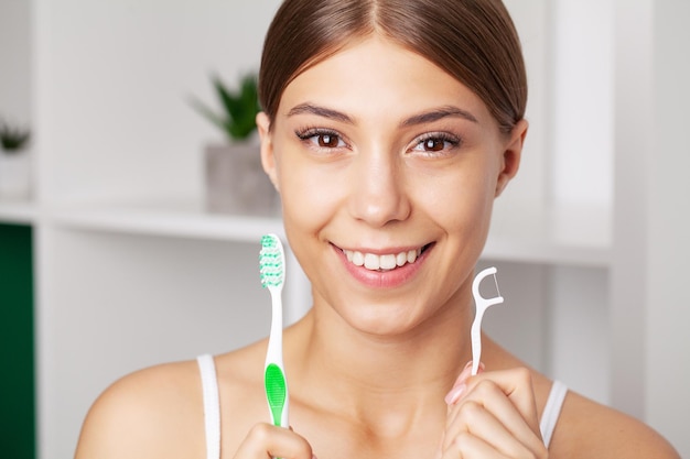 Beautiful young woman brush her teeth in the bathroom