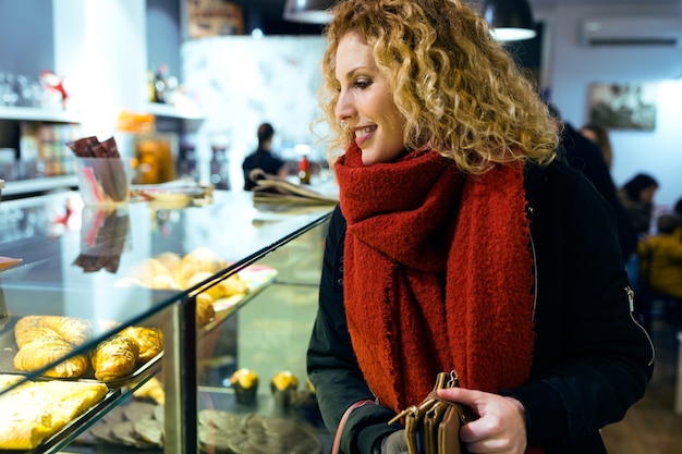 Beautiful young woman buying coffee in a coffee shop.