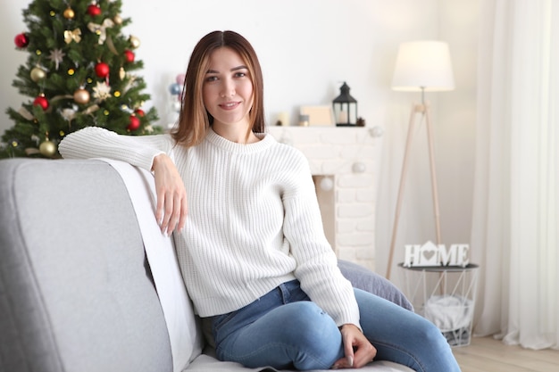 Beautiful young woman in a christmas interior with gifts place for text