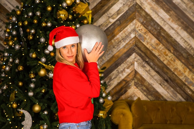 Beautiful young woman decorating christmas tree