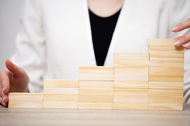 Beautiful young woman demonstrates on wooden bars business development concept