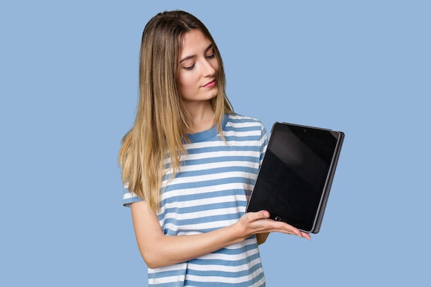 A beautiful young woman displays a sleek tablet showcasing her techsavvy and modern style