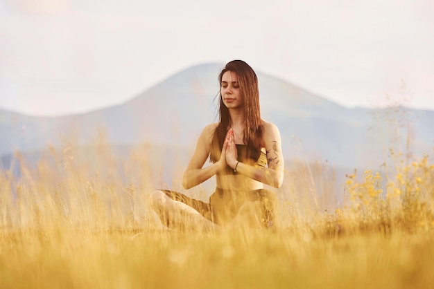 Beautiful young woman doing yoga exercises Majestic Carpathian Mountains Beautiful landscape of untouched nature