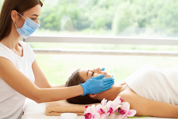 Beautiful young woman enjoying massage in spa salon