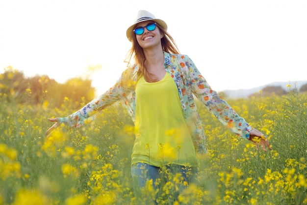 Beautiful young woman enjoying summer in a field.