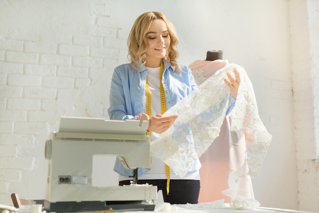 beautiful young woman in a factory with a sewing machine at the table