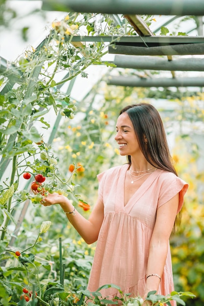 Beautiful young woman gardening in the greenhouse