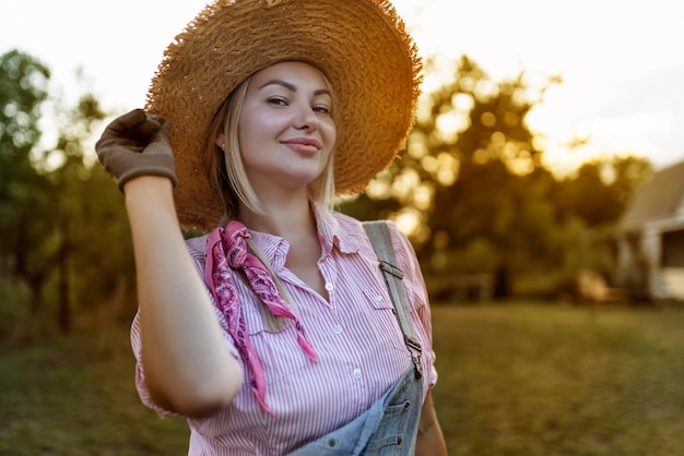 Beautiful young woman gardening outside in summer nature