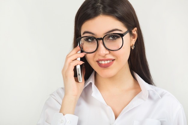 Beautiful young woman in glasses with a phone