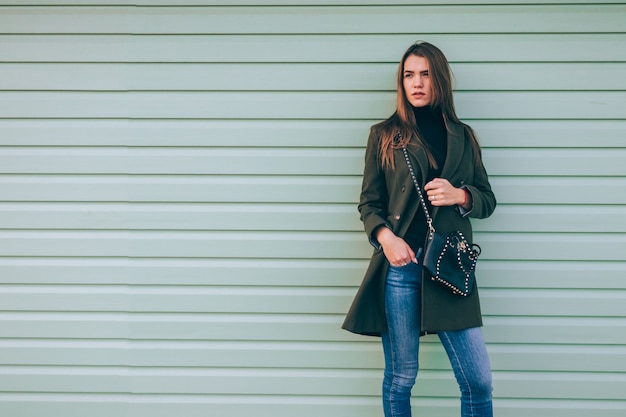 Beautiful young woman in green coat