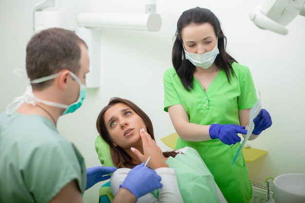 Beautiful young woman having dental treatment at dentist