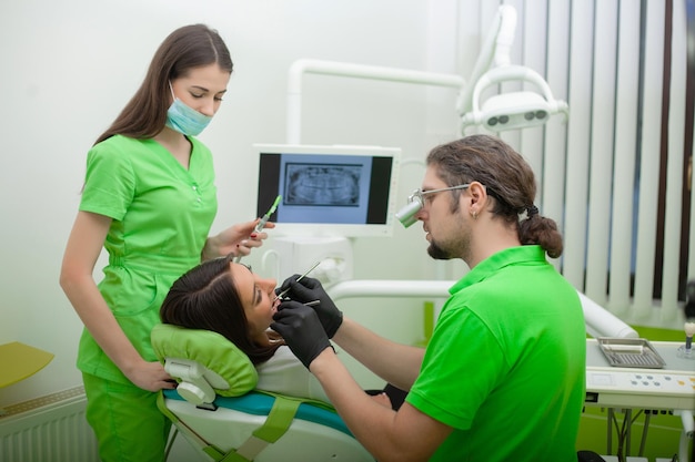 Beautiful young woman having dental treatment at dentist