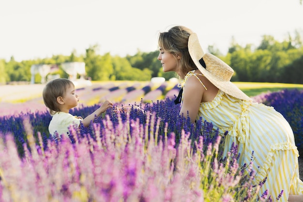 Beautiful young woman and her cute baby son in the lavender field