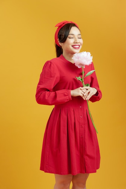 Beautiful young woman holding big pink peony