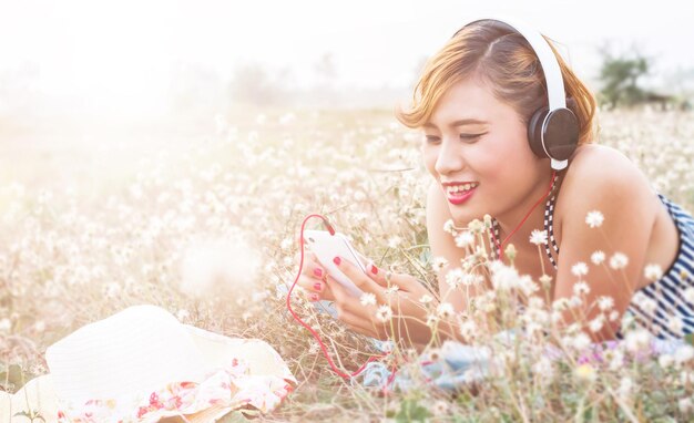 Photo beautiful young woman holding flower on field