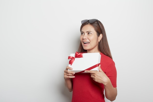 Photo beautiful young woman holding gift box against white background