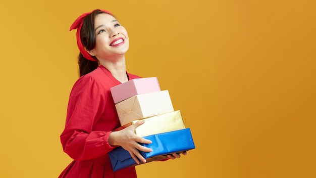 Beautiful young woman holding a lot of boxes with Christmas and New Year's gifts