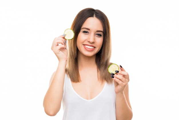 Beautiful young woman holding slices of cucumber