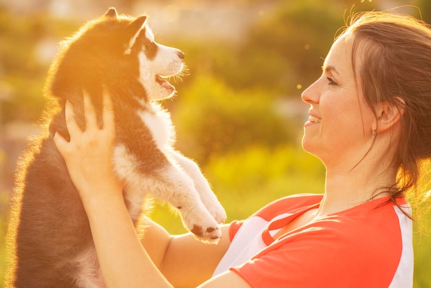 Beautiful young woman is playing with her puppy dog outdoor