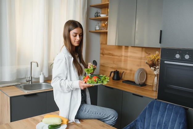 Beautiful young woman is preparing vegetable salad in the kitchen Healthy Food Vegan Salad Diet Dieting Concept Healthy Lifestyle Cooking At Home