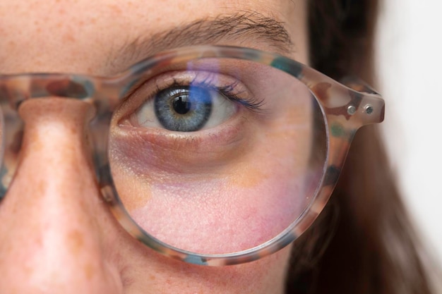 A beautiful young woman is seen upclose wearing vintage eyeglasses as she looks straight