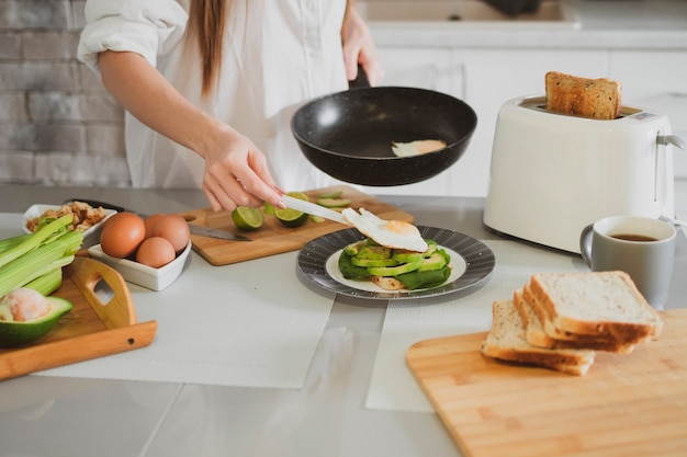 Beautiful young woman in the kitchen at home prepares healthy food