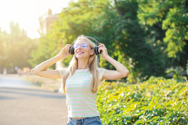 Beautiful young woman listening to music outdoors