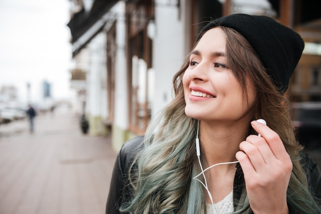 Beautiful young woman listening music with earphones.