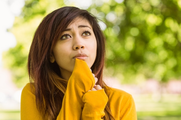 Beautiful young woman looking away in park