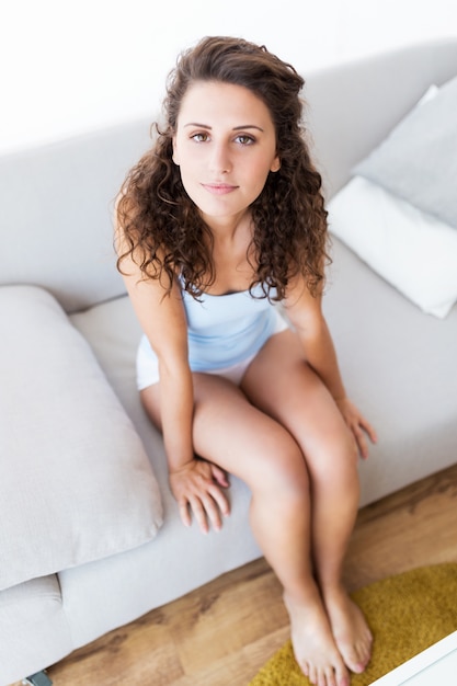 Beautiful young woman looking at camera at home.