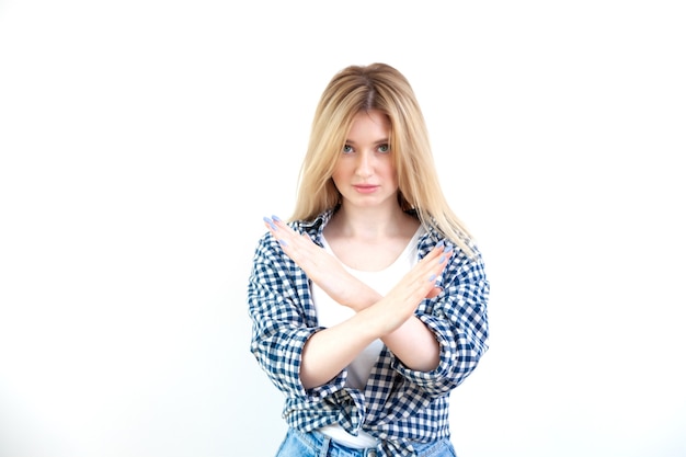 Beautiful young woman makes stop gesture, crossed arms