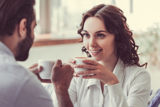 Beautiful young woman and man in love are drinking coffee.