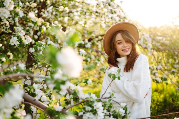 Beautiful young woman near blooming spring tree Youth love romantic concept