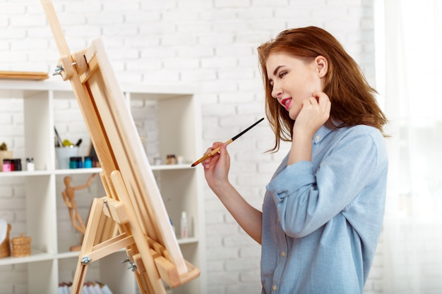 Beautiful young woman painter at work