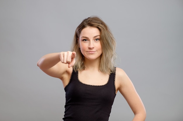 Beautiful young woman pointing at the camera