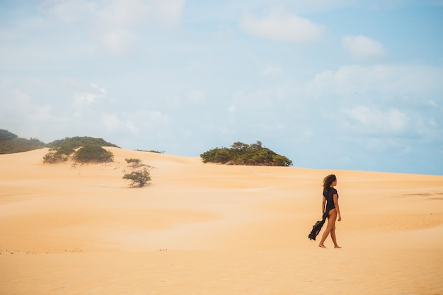 Beautiful young woman posing in the desert sand