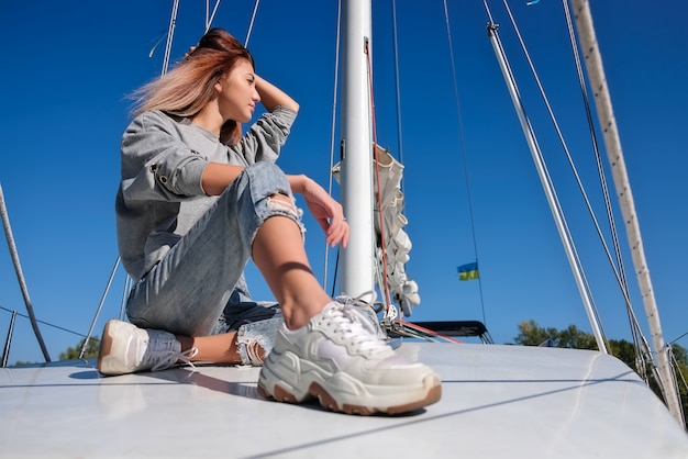 Beautiful young woman posing on yacht.