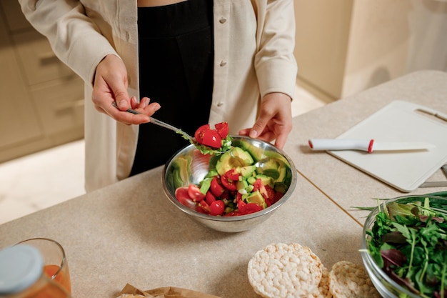 Beautiful young woman preparing vegetable vegan salad in the kitchen Healthy food and diet concept lifestyle Cook at home