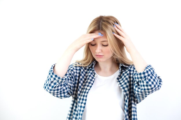 Beautiful young woman puts hands on head, feel headache