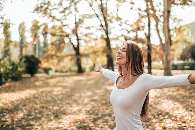 Beautiful young woman relaxing in the park with her arms spread.