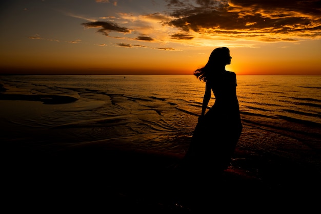 Beautiful young woman relaxing at sunset