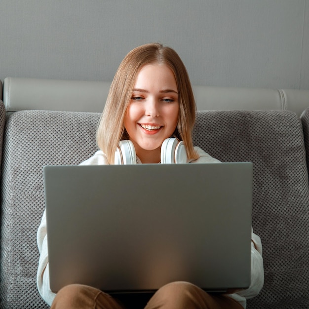 Beautiful young woman do remote work online study from home via laptop Teenager have Convenient work space with computer laptop Teen in Cozy home office on couch freelancer remote work Square