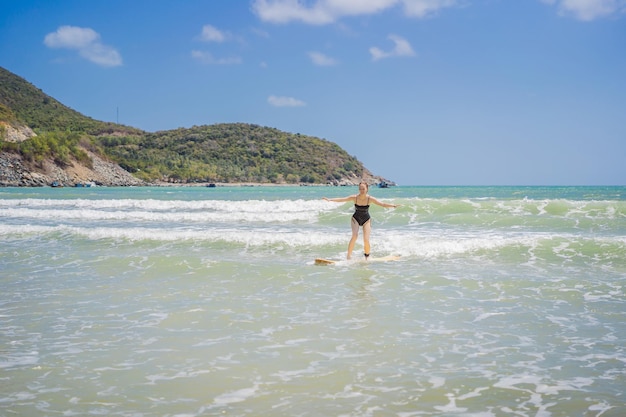 Beautiful young woman ride wave sporty surfer woman surfing on the background of blue sky clouds and