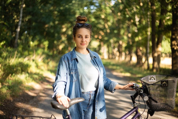 Beautiful young woman rides a bike in the park