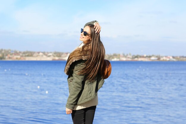 Beautiful young woman at seashore on sunny autumn day