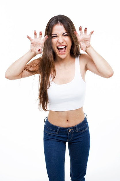 Beautiful young woman shouting and growling like an animal over white background.