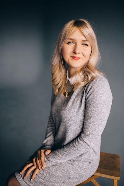 Beautiful young woman sitting on the chair isolated