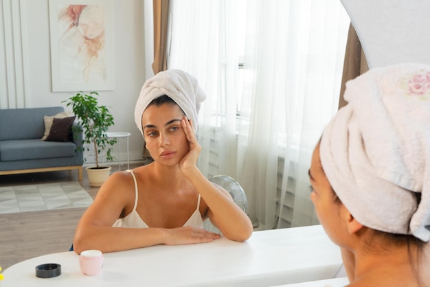 Beautiful young woman sitting in front of mirror at home