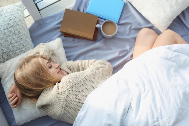 Beautiful young woman sleeping at home top view Winter atmosphere