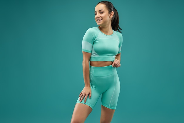 Beautiful young woman in sportswear expressing positive emotions